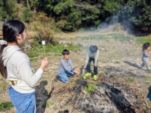 阿東の自然体験。焚き火を囲みながら遊ぶ子どもたちの姿。