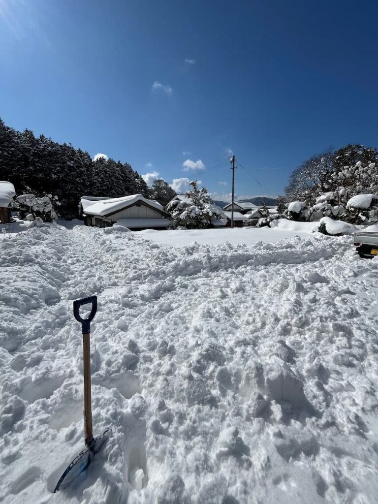 阿東の冬の雪景色。積雪に覆われた古民家と青空が広がる風景。