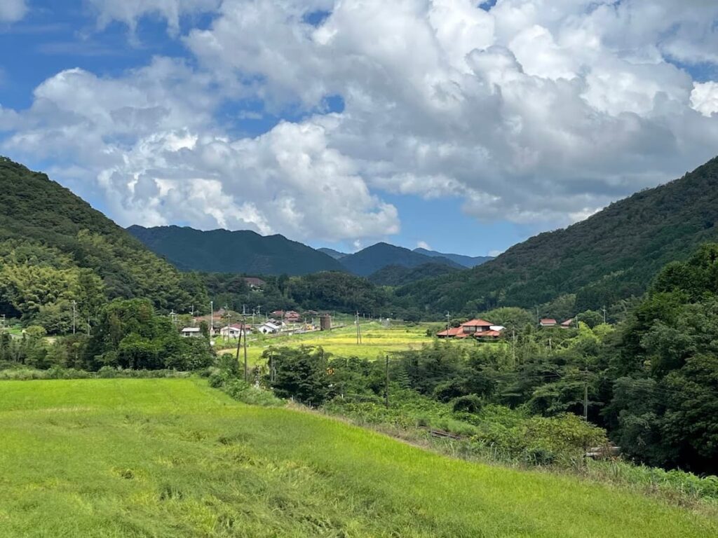 山口市阿東・細野地区の田園風景。緑豊かな棚田と山並み、赤瓦屋根の家々が広がる日本の原風景。