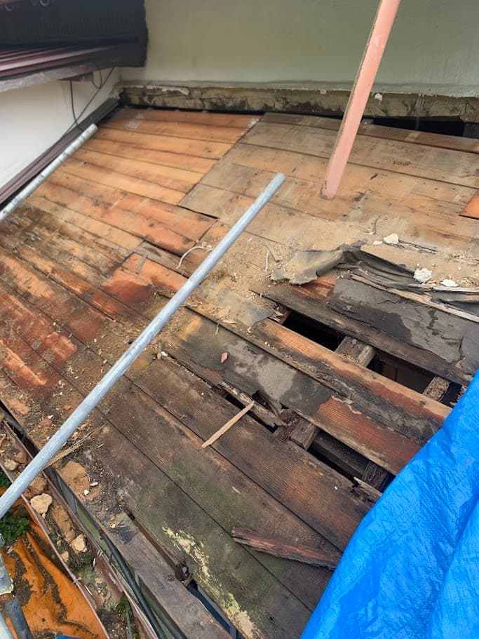 改修前の屋根部分。長年の雨漏りによって木材が腐食し、屋根板が大きく傷んでいる様子。