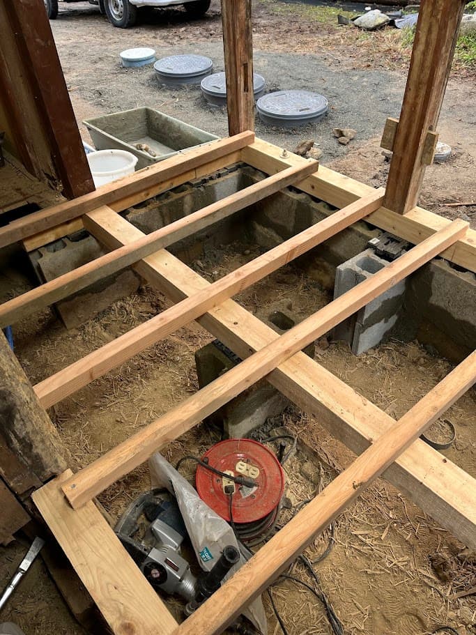 新しいトイレ床の土台を組み直している途中。木材で骨組みを作り、安定した基礎を再構築している。