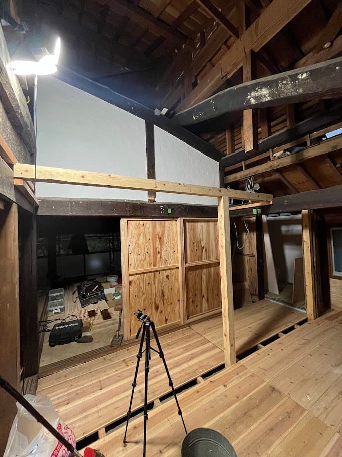 新しいトイレへ続く廊下の骨組みを施工している様子。梁の下に新しい柱と床材を組み、通路の形が現れてきた段階。