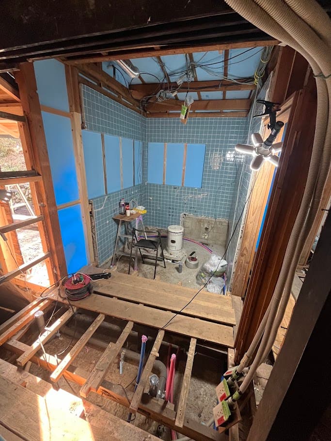 洗面所の配管工事中の様子。床を一部解体し、新しい給排水管を通している。