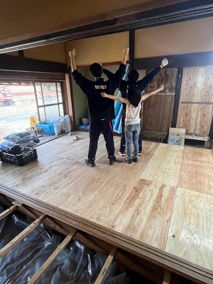 古民家の床下地づくりを家族と一緒に行う様子。完成を喜ぶ子どもたちの姿が印象的な一枚。